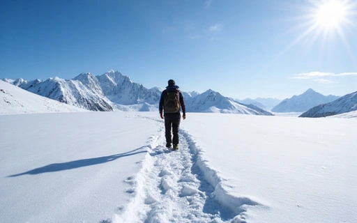 A lone snowshoer traversing a pristine snowfield with distant mountains